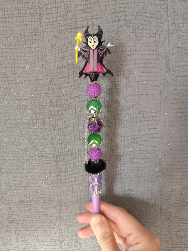 Stylo Maléfique – Perles Mauves, Vertes & Pompon Noir
