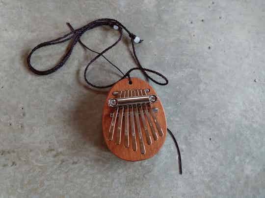 Houten vingerpiano aan een ketting