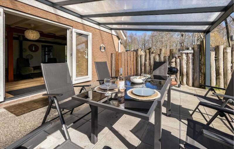 Overdekt terras met tuinmeubilair bij vakantiehuis Lauwersrust