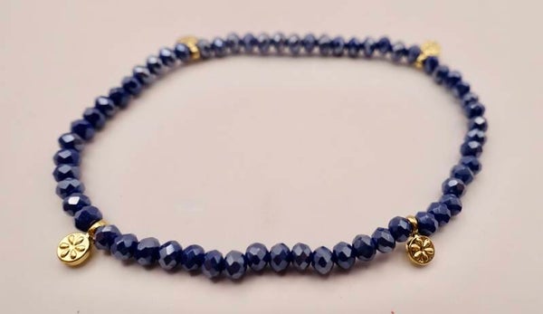 ARbl034724: Donkerblauw, heel fijn armbandje met goudmetalen bedeltjes.