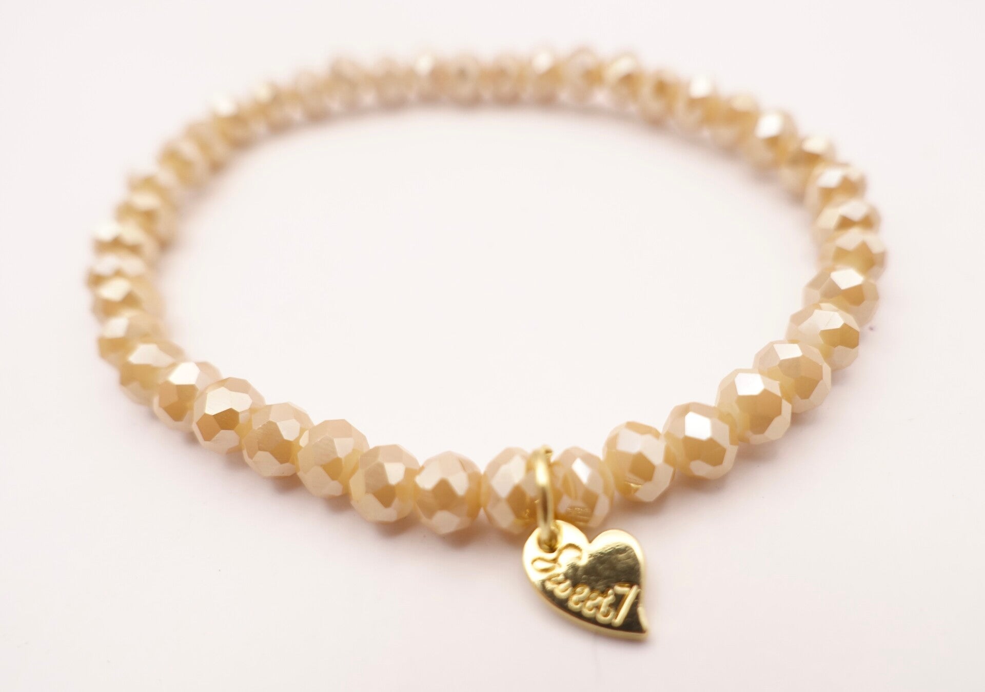 ARec084724: Ecru/creme armbandje met goudmetalen bedeltje.