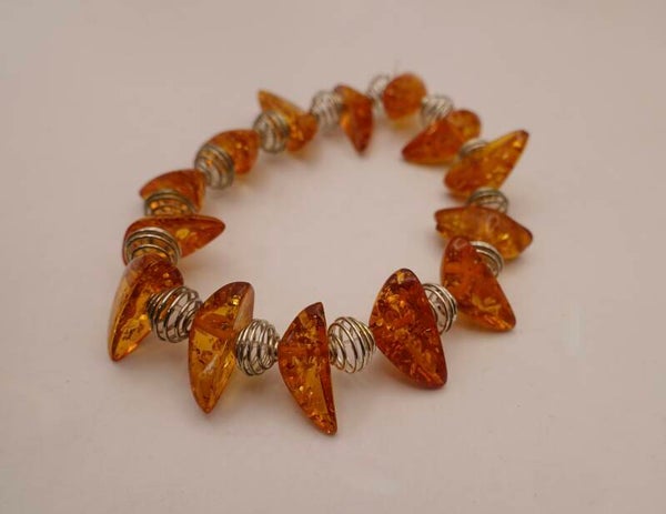 ARor014026: Barnsteen armband afgewisseld met zilvermetalen draadkralen.