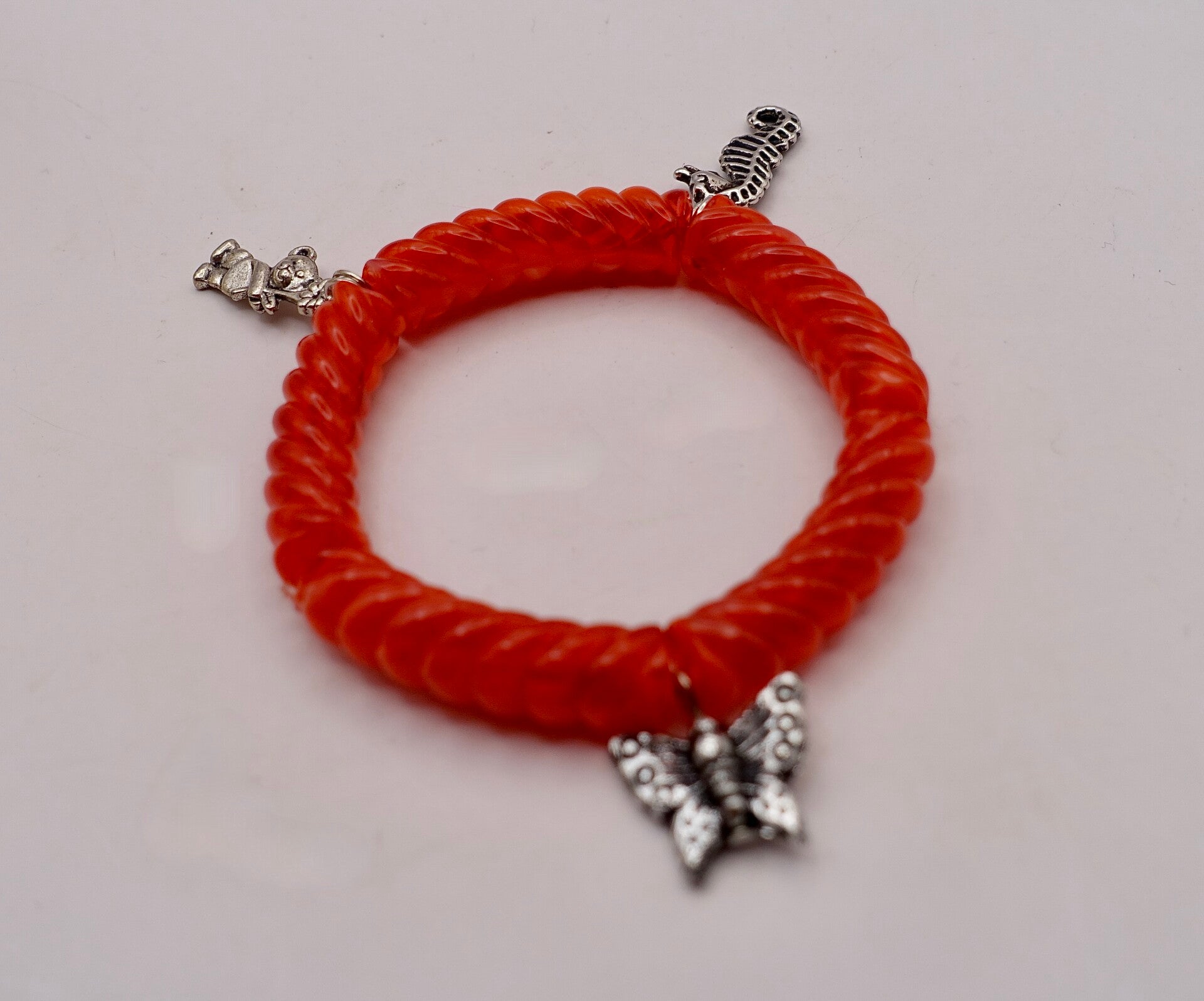 ARro020926; Rood geribbeld armbandje met bedeltjes.