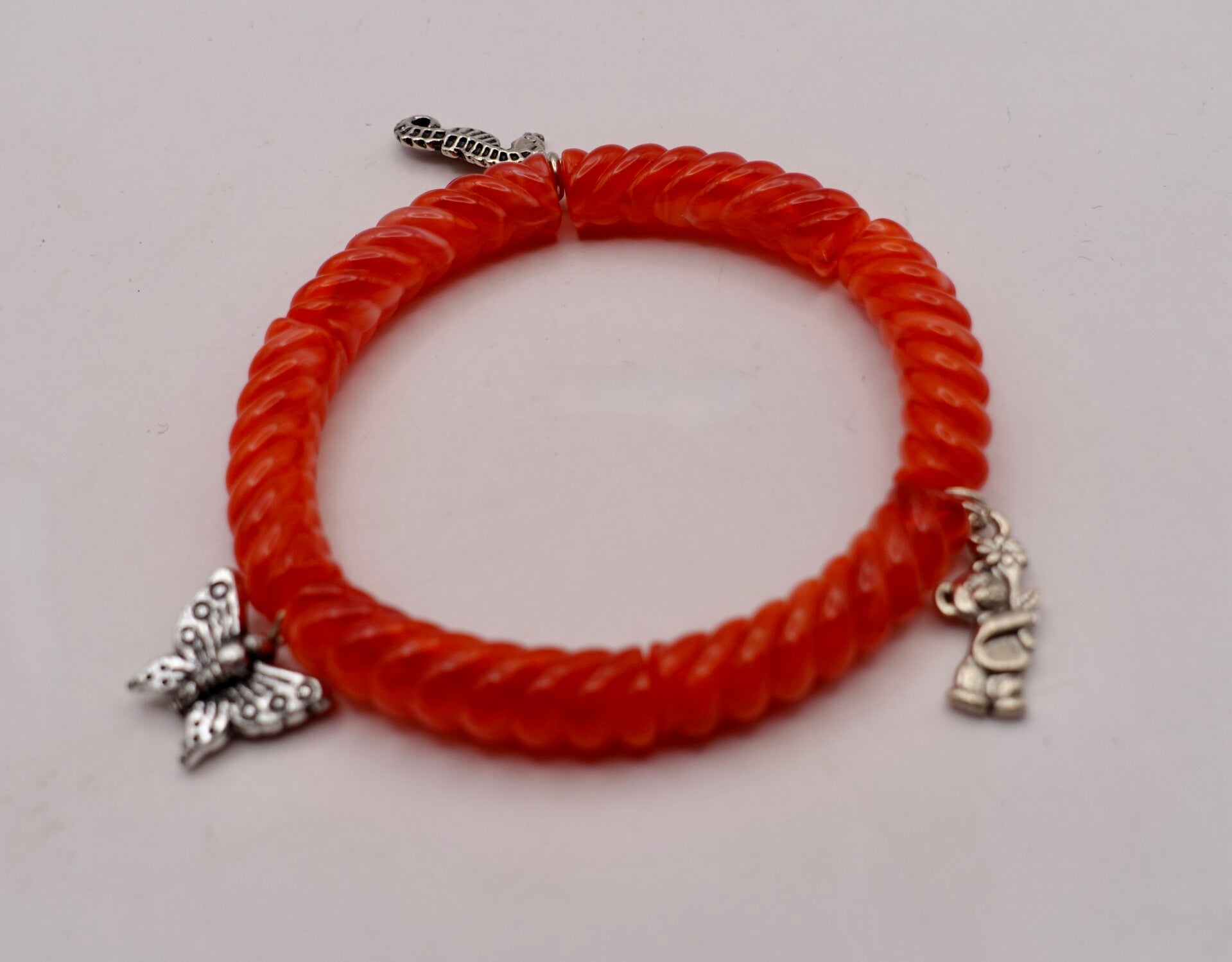 ARro030926: Rood geribbeld armbandje met bedeltjes