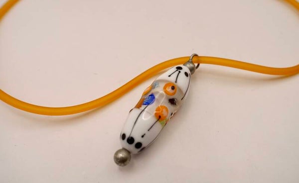Hanor012425: Prachtige hanger in wit/oranje/zwart aan rubberen, oranje kettinkje.