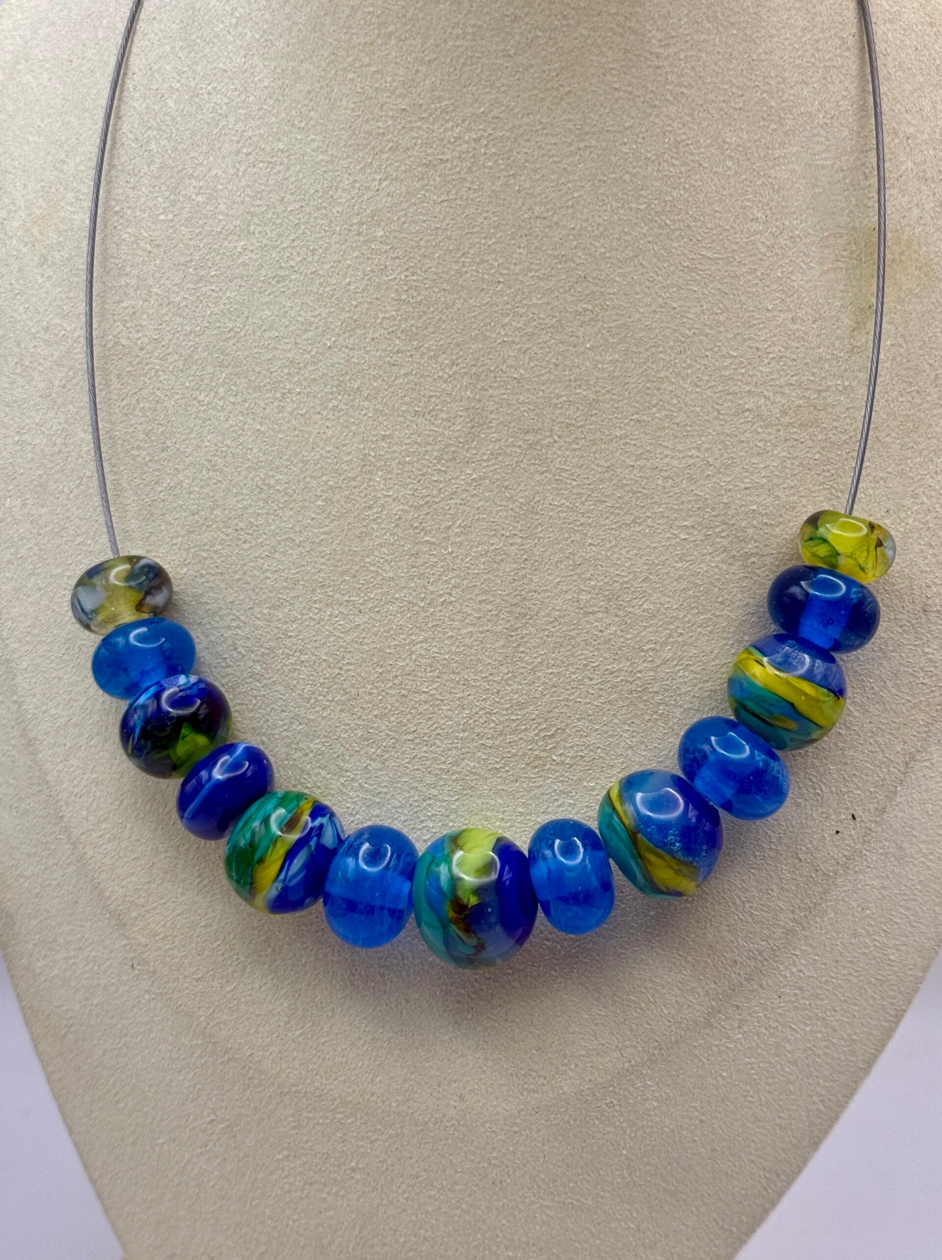 KKbl011626: Ketting met handgemaakte kralen in div. blauwtinten met groen.