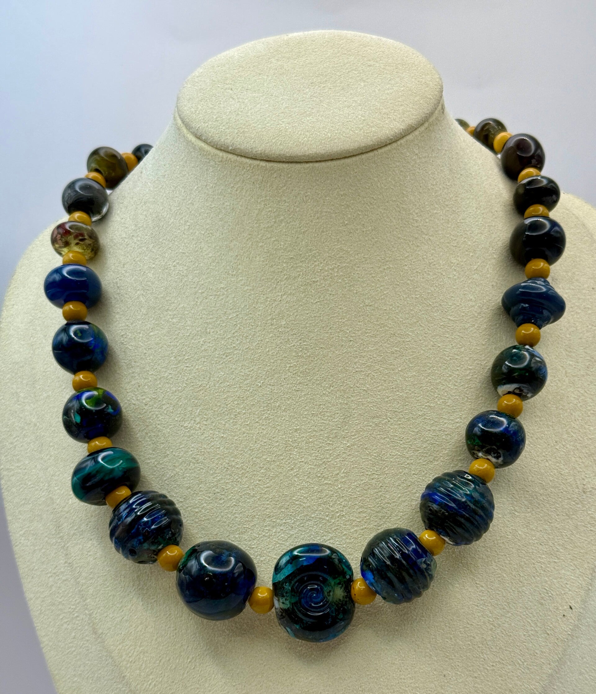 KKbl011726: Ketting in donkerblauw/groen/oker van handgemaakte kralen.