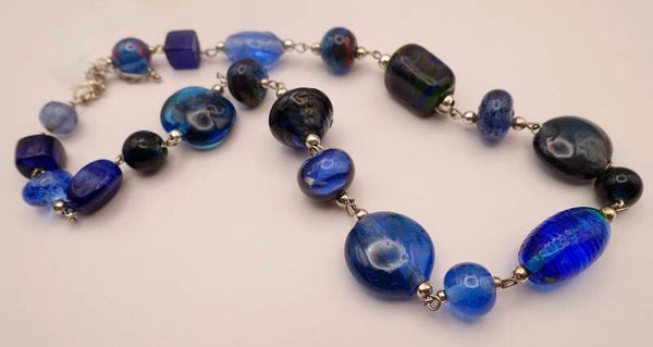 KKbl014524: Ketting van handgemaakte glaskralen in meerdere tinten blauw.