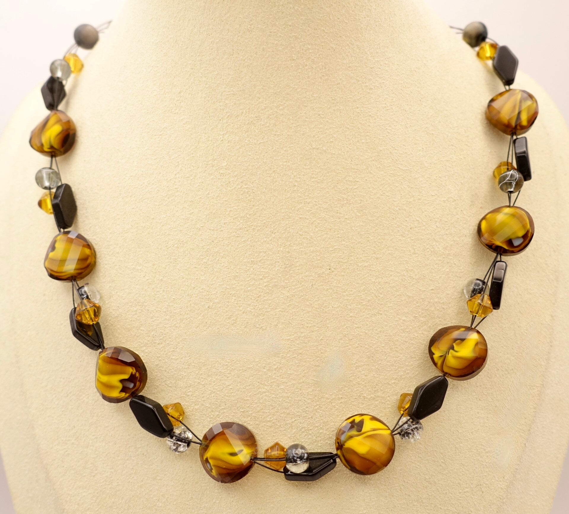 KKge013825: Heel aparte ketting in warm okergeel met zwart.