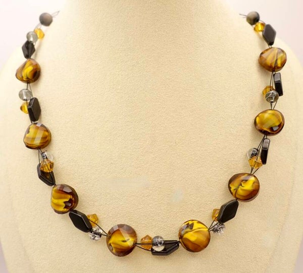 KKge013825: Heel aparte ketting in warm okergeel met zwart.