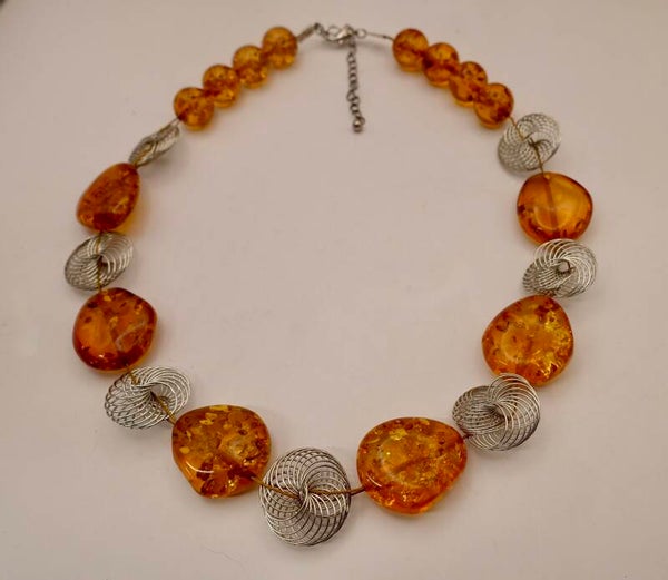 KKor014026: Barnsteen ketting afgewisseld met zilvermetalen draadkralen.
