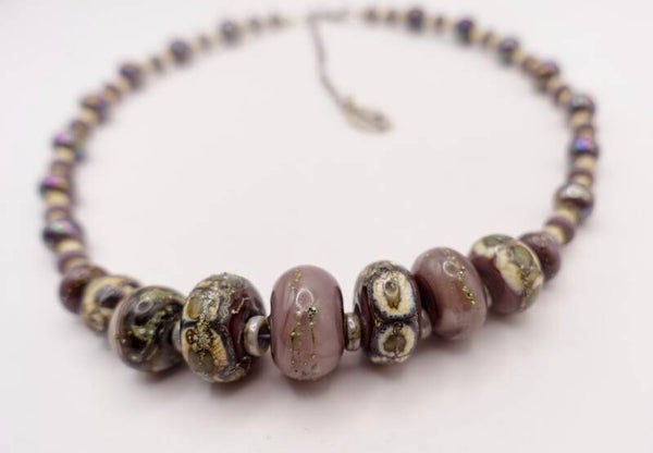 KKpa011525: Ketting in zachtlila, taupe, ecru, etc. met zilverdraad bewerkt.