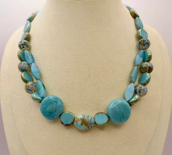 KKtu013125: Ketting in turquoise met taupe van glas en keramiek.