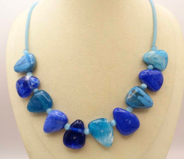 KKtu013826: Handmade kralen in blauw, turquoise, kobalt, etc. aan turquoise rubber ketting.