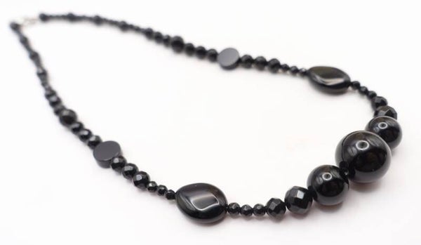 KKzw024625: Kettinkje van zwart natuursteen.