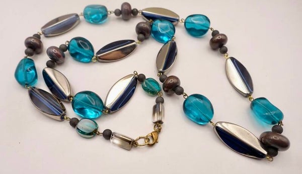 KLpetr012326: Lange ketting in petrol, donkerblauw en zilverkleur.