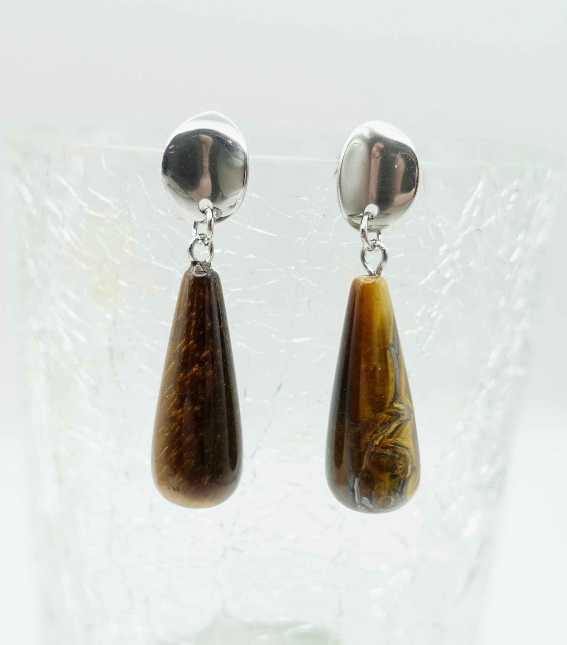 OBbr014924: Bruine tijgeroog pegels als oorhanger aan zilvermetalen DQ steker.