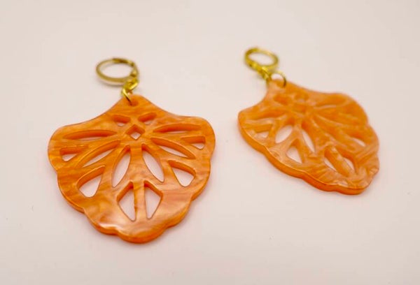 OBor013724: Opengewerkte terra/warm oranje oorhangers aan kleine creolen.