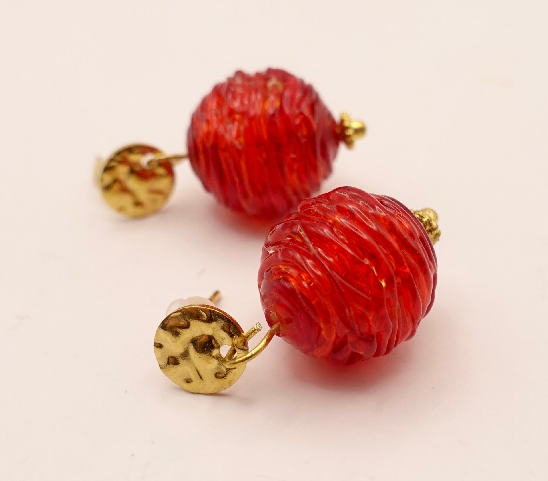 OBro011525: Warmrode, holle kralen aan DQ goudmetalen oorstekers.