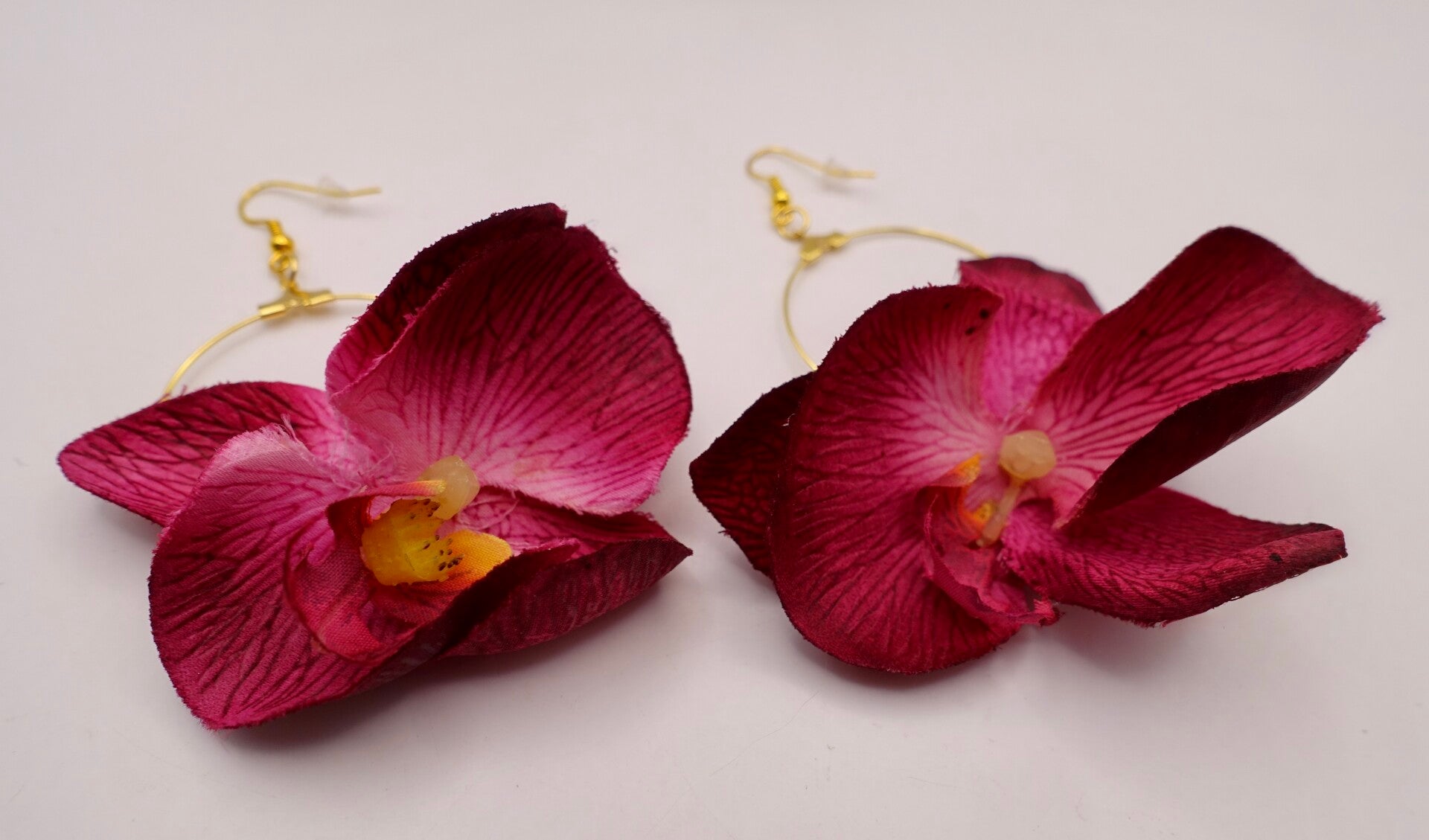 OBro015025: Diep donkerrode bloemoorbellen aan goudmetalen creolen.