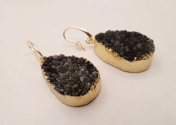 OBzw011525: Zwartgrijze oorhangers van rough natuursteen, afgewerkt met goudmetaal en goldfilled hangers.