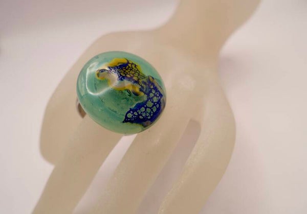 Toptu010425: Handgemaakte ring-/hangertop in zacht zeegroen met blauw en geel.