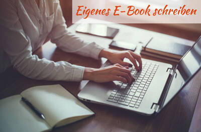 Das Bild "Eigenes E-Book schreiben" zeigt einen Schreibtisch mit einem Laptop und einem aufgeschlagenen Notizbuch. Am Schreibtisch sitzt eine Person und tippt Texte am Laptop.
