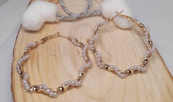 Anneaux dorés ornés de perles blanches.