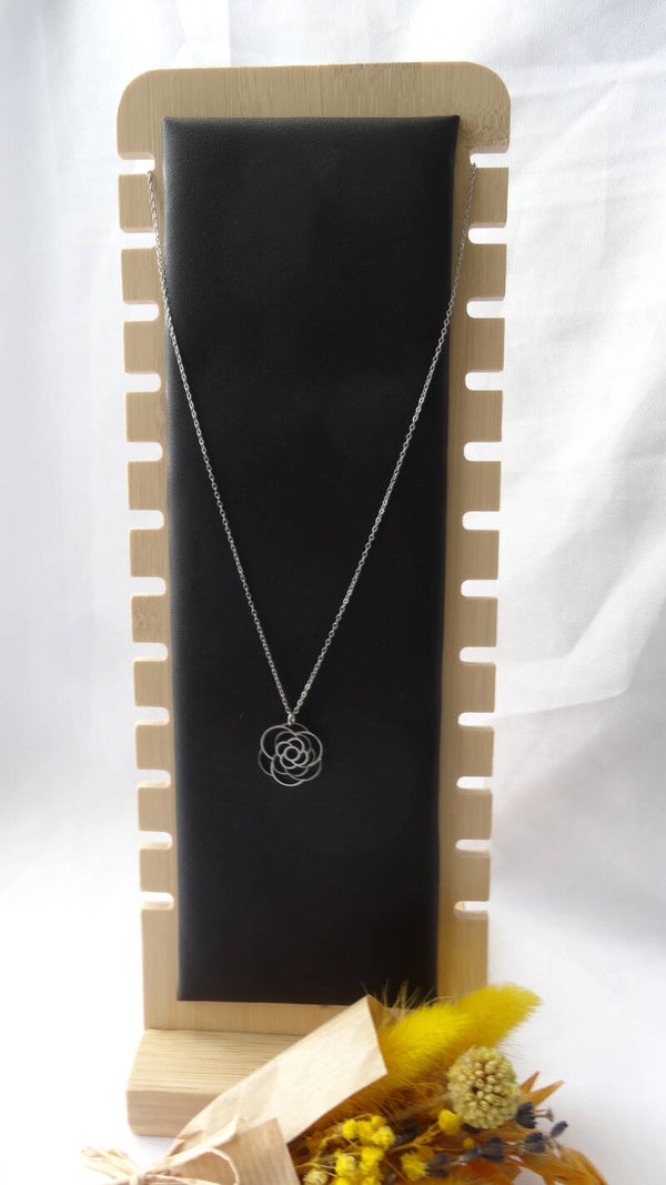 Collier argenté avec un pendentif représentant une rose.