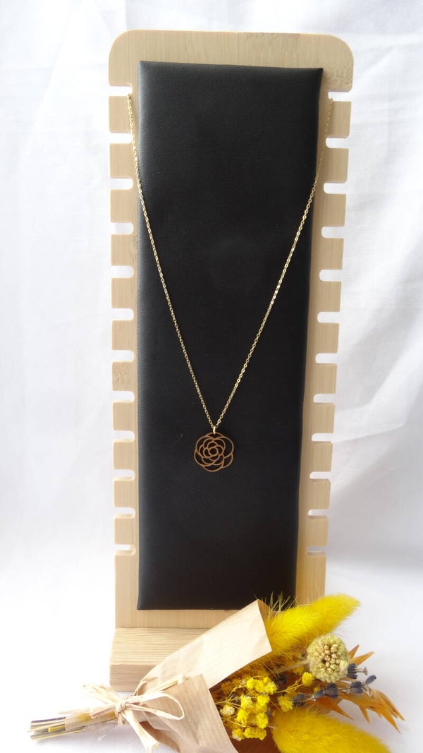 Collier doré avec un pendentif représentant une rose.