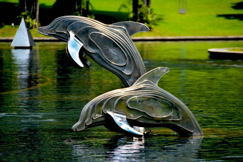 gray-and-brass-metal-dolphin-pool-decor
