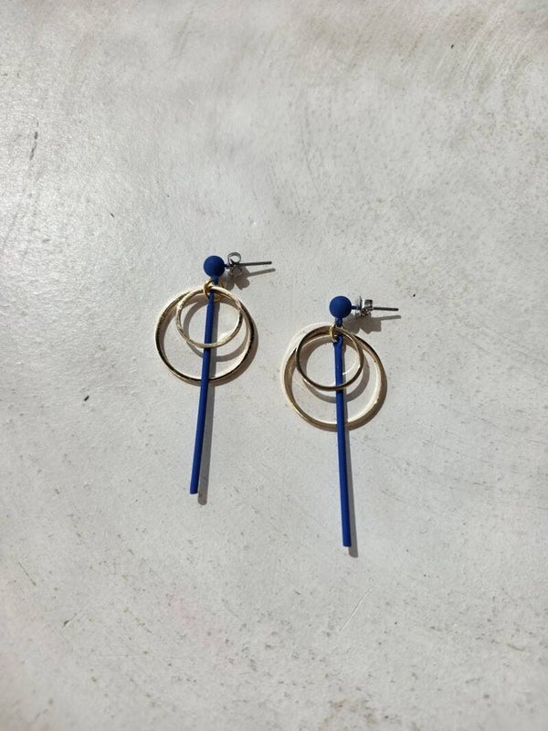 Lange koningblauwe oorbellen (oorstekers) met gouden cirkels.