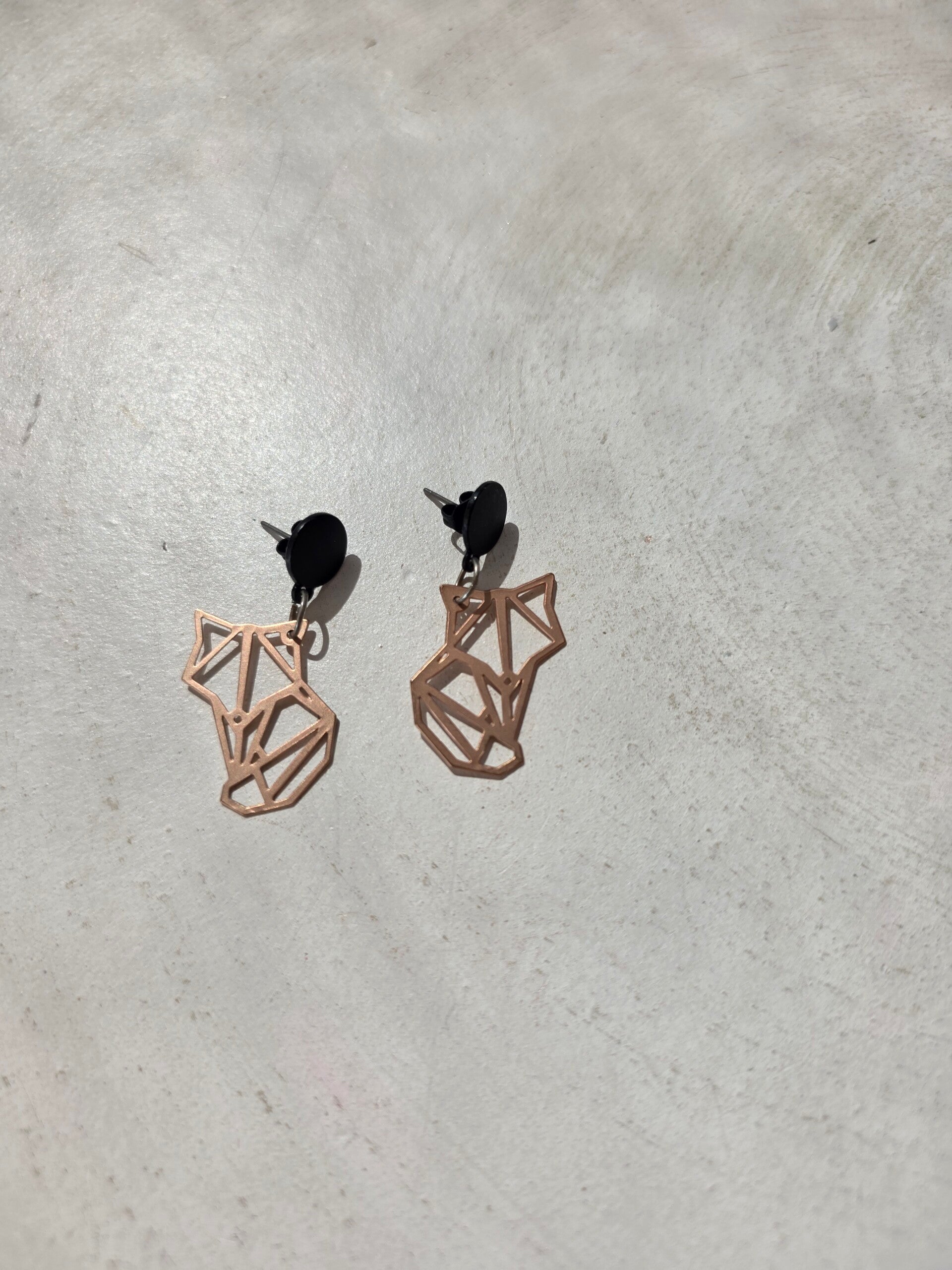 zwarte cirkelvormige oorstekers met een hanger in dierlijke vorm