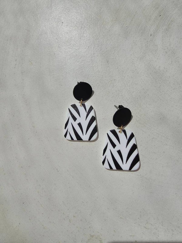 zwarte oorsteker en witte trapeziumvormige hanger met zwarte strepen