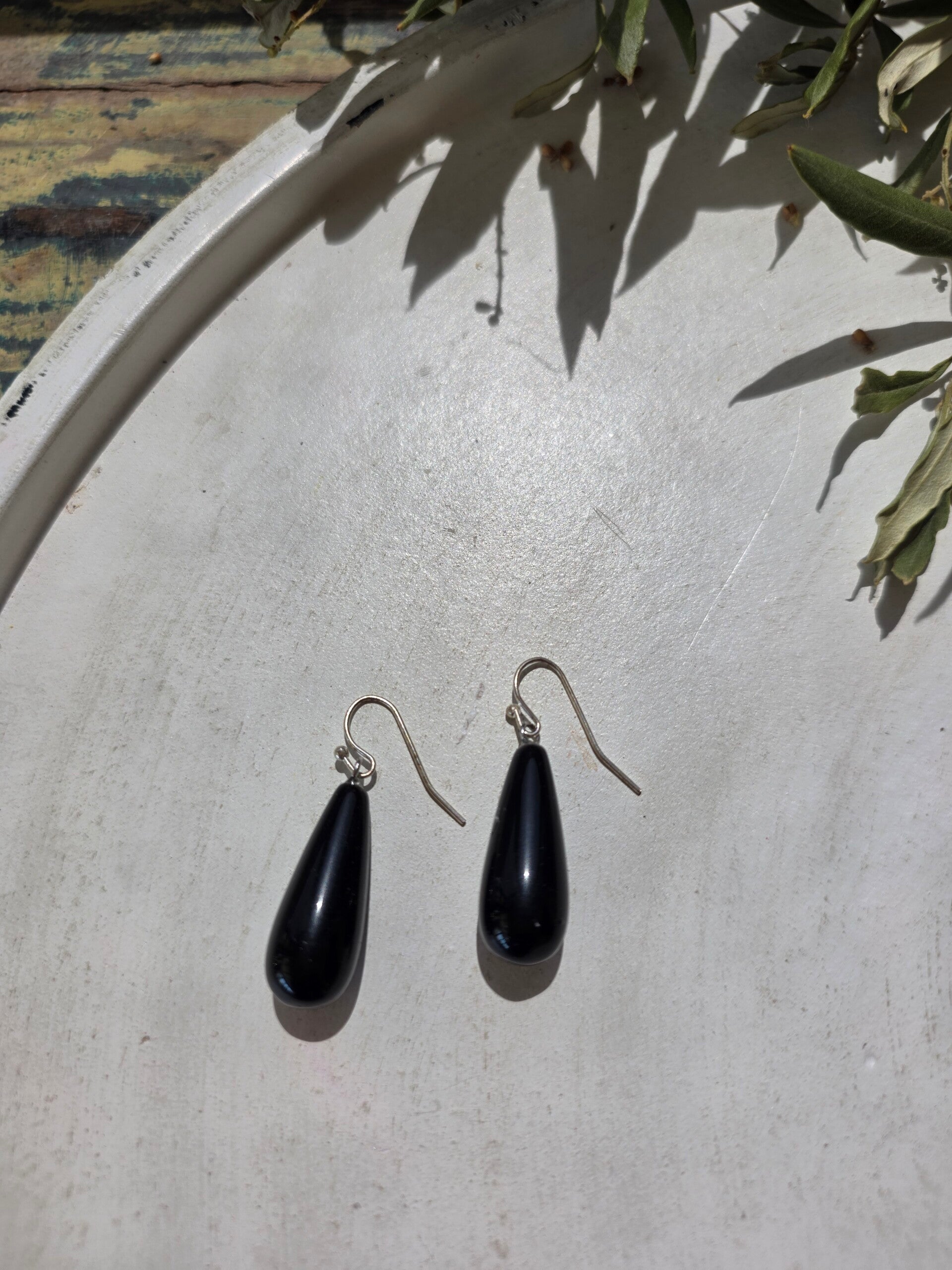zilverkleurige oorhangers met een druppelvormige bedel uit obsidiaan