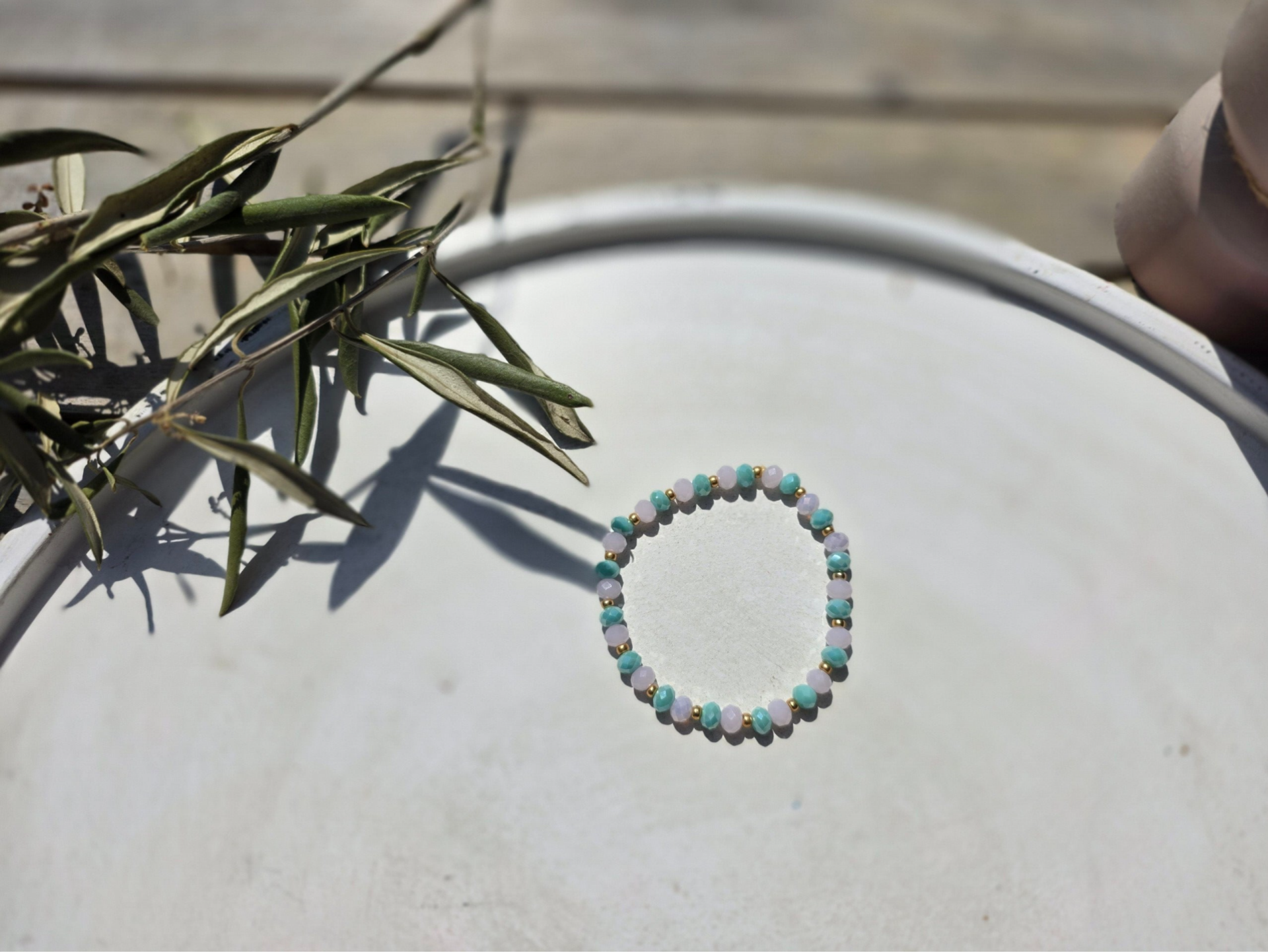 armband uit facetkralen in roze en mint en gouden knijpkralen