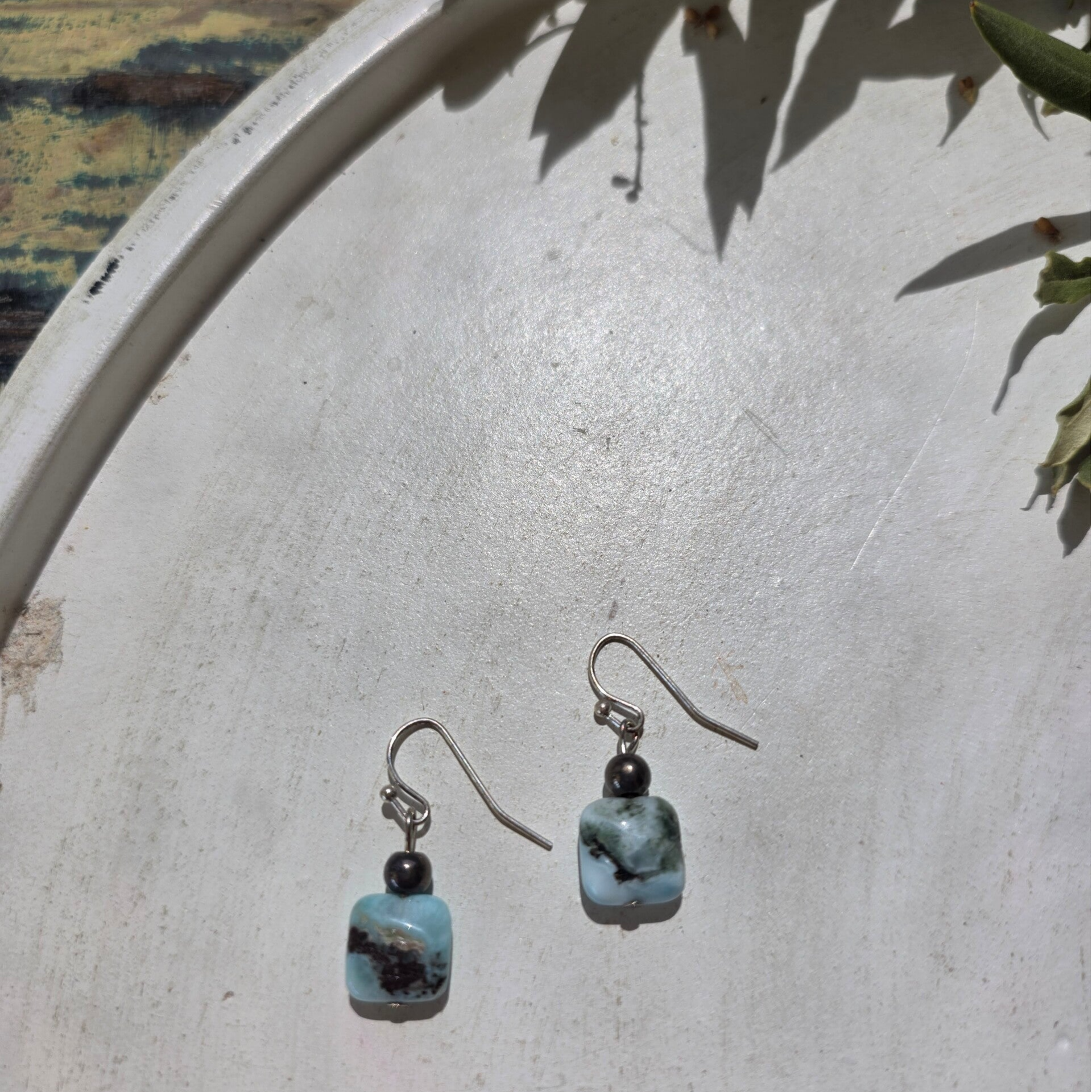 zilverkleurige oorhangers met een bedel uit larimar en een donkergrijze ronde kraal