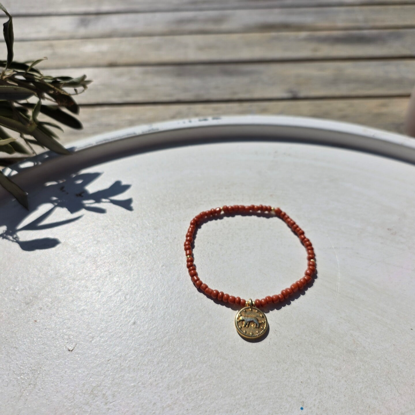armband uit rocailles (bruin) en gouden kralen en bedeltje