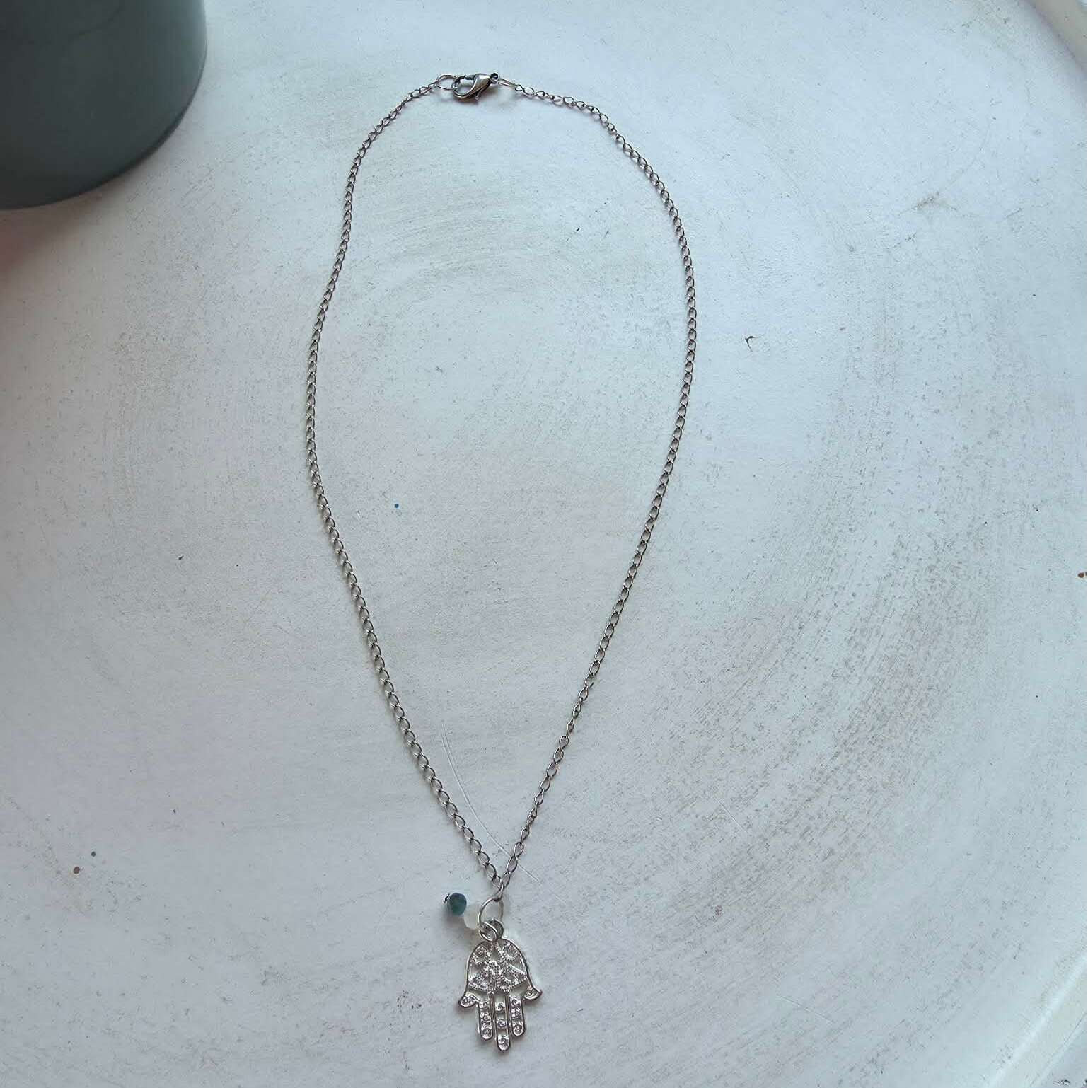 ketting in zilverkleur met bedel (hand van fatima) en hanger uit maansteen en apatiet