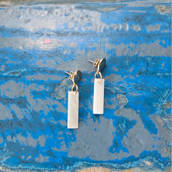 gouden cirkelvormige oorsteker met witte rechthoekige hanger