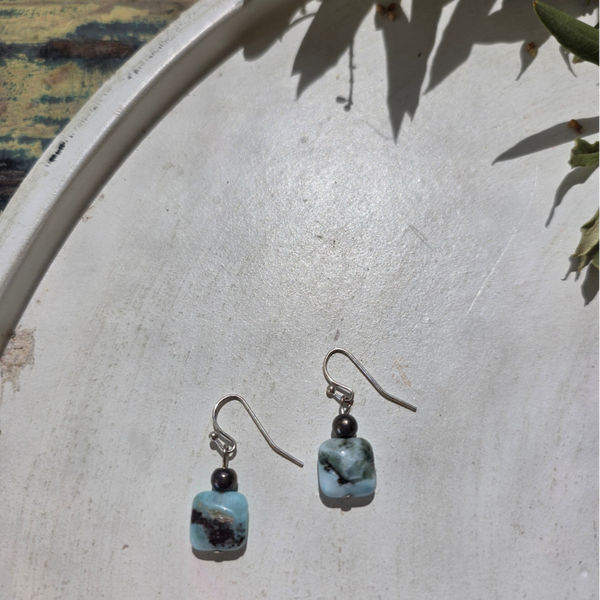zilverkleurige oorhangers met een bedel uit larimar en een donkergrijze ronde kraal
