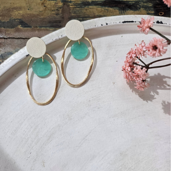 witte cirkelvormige oorstekers, met gouden en mintgroene bedels