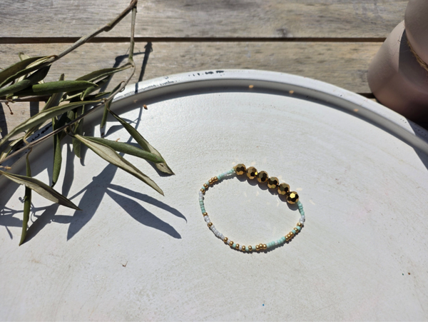 armband uit rocailles (3mm) in wit, goud en mint afgewerkt met grote bronskleurige facetkralen