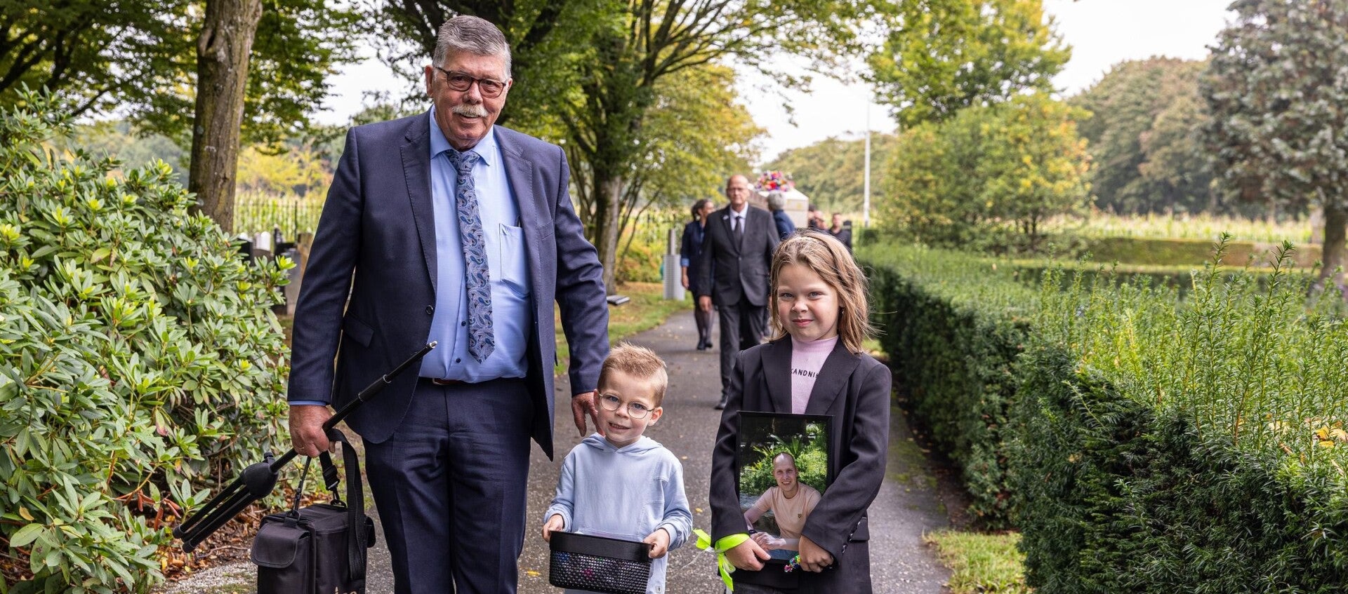 Vrouw begeleidt kind bij bloemstuk tijdens rouwmoment