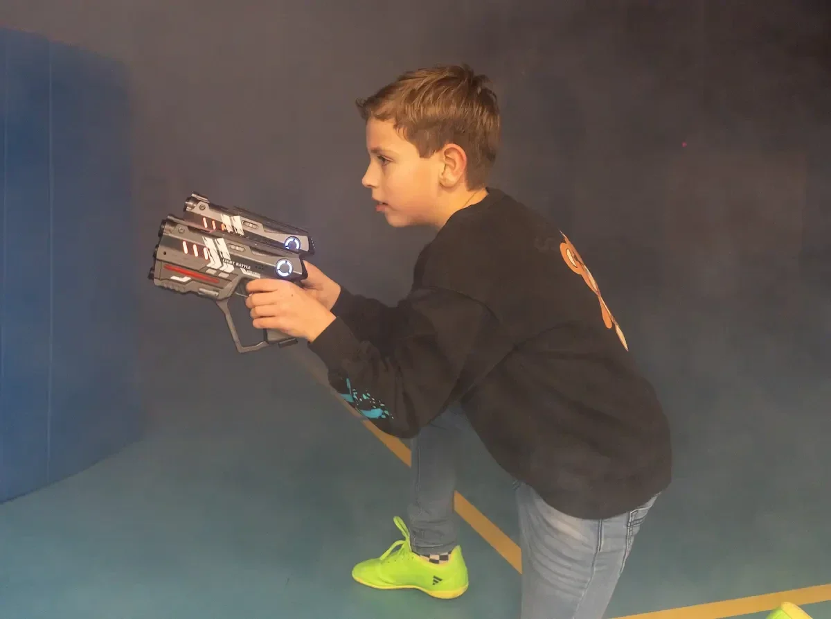 Kinderen lasergamen tijdens een kinderfeestje in een gymzaal. Lasergame regio Harskamp, Ede en Barneveld.