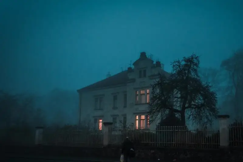 "maison hantée inspirée Amityville nuit fenêtres lumineuses ambiance paranormal"