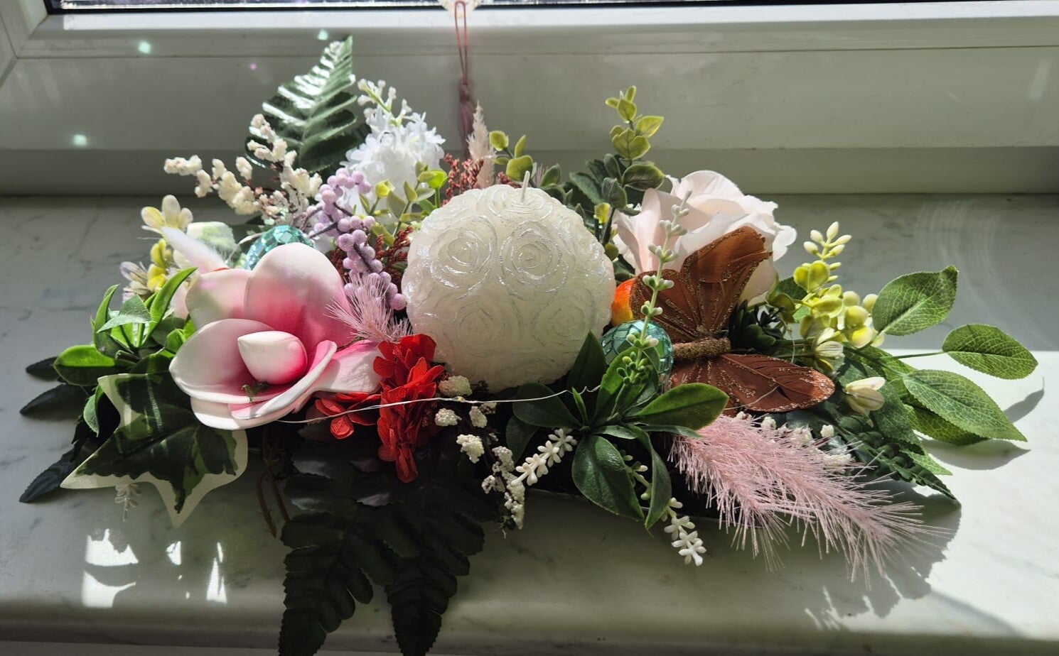 Elegantes Blumengesteck mit Kerze