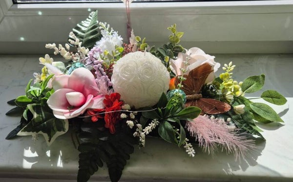 Elegantes Blumengesteck mit Kerze