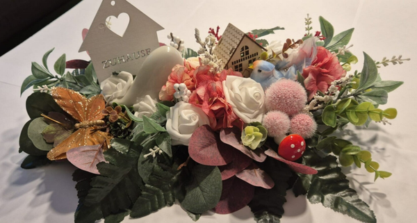 Blumengesteck mit weißen Häuschen