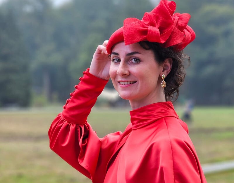 Mirjam draagt een rode fascinator tijdens Royal Polo at the Palace 2023